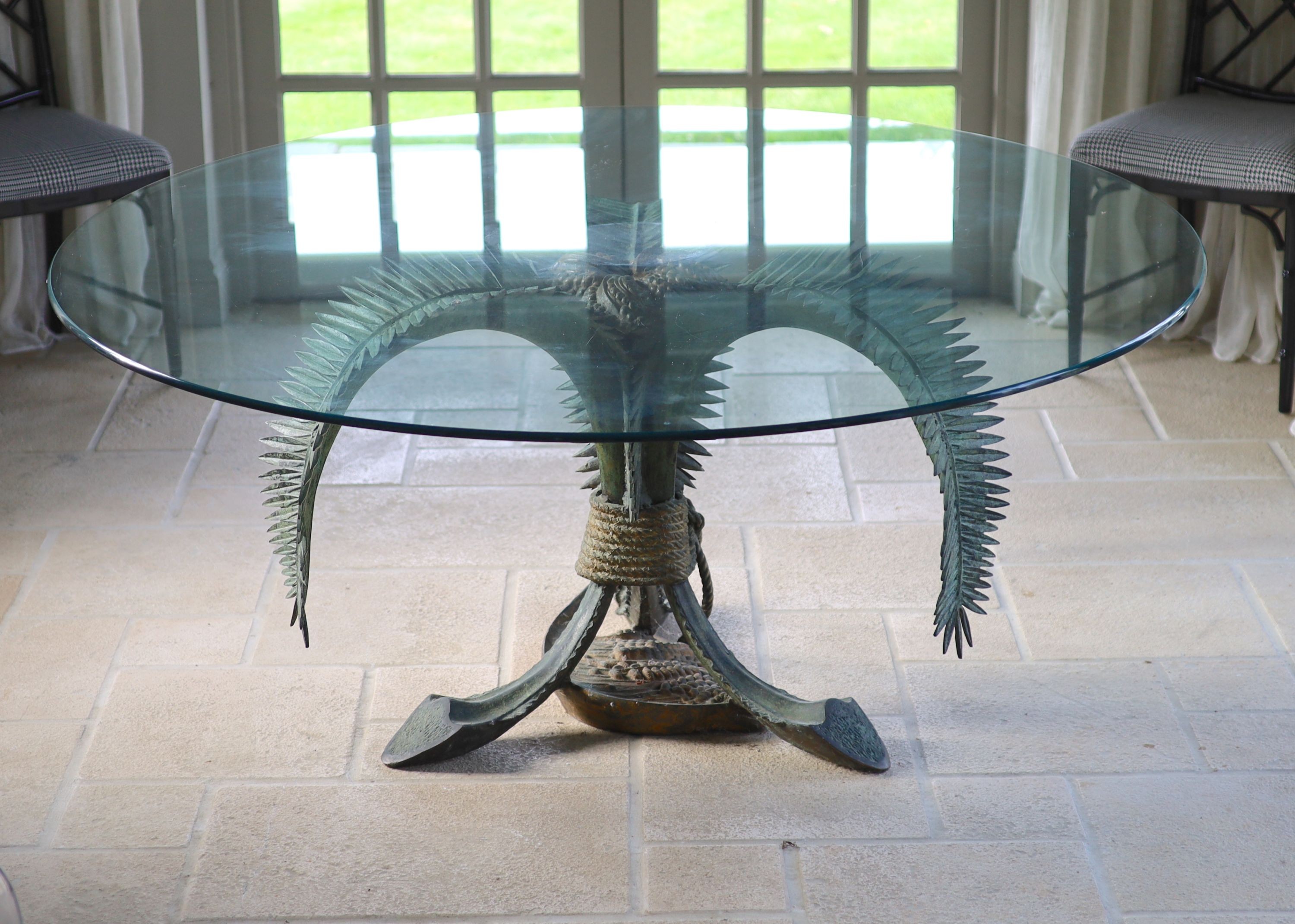 A patinated bronze and glass palm leaf centre table, the circular top 165cm height 75cm